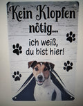 Cuadro de madera Jack Russell Terrier asomando por cortina con huellas negras y frase en alemán Kein Klopfen nötig ich weiß du bist hier