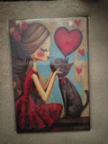 Cuadro de madera chica y gato negro con corazones rojos