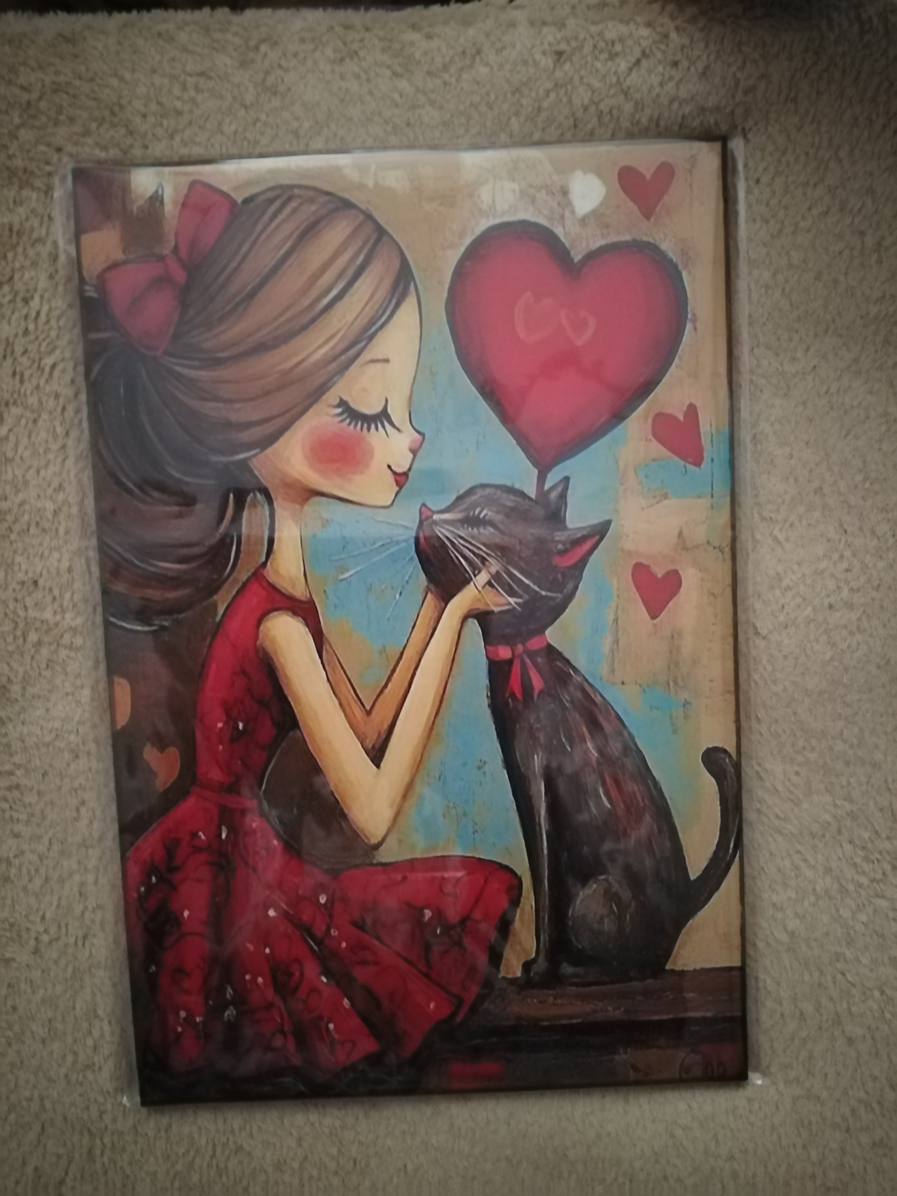 Cuadro de madera chica y gato negro con corazones rojos
