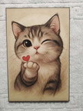 Cuadro de madera gatito atigrado guiñando un ojo con corazón rojo en la patita