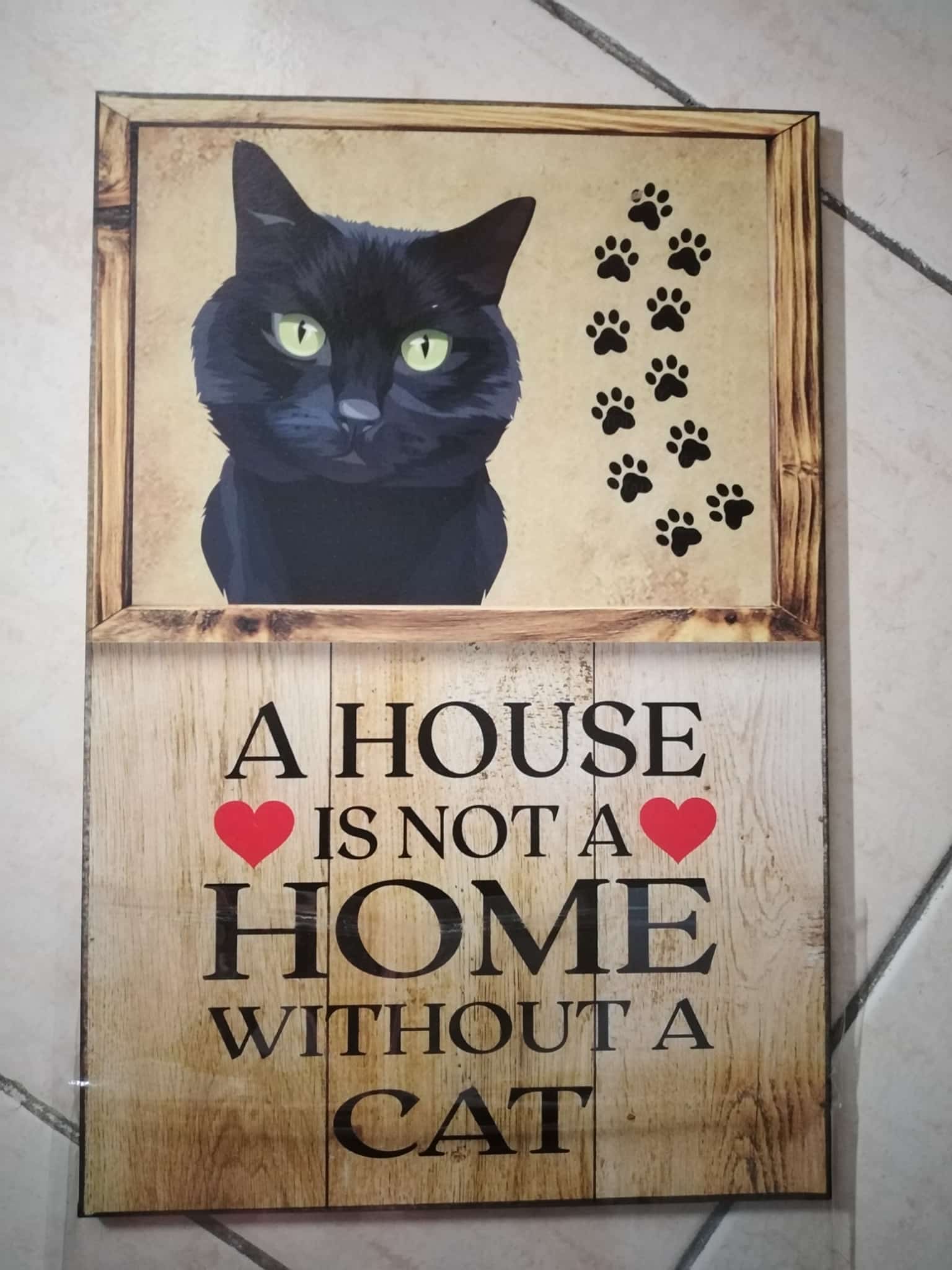 Cuadro de madera gato negro ojos verdes con huellas y frase A House Is Not a Home Without a Cat
